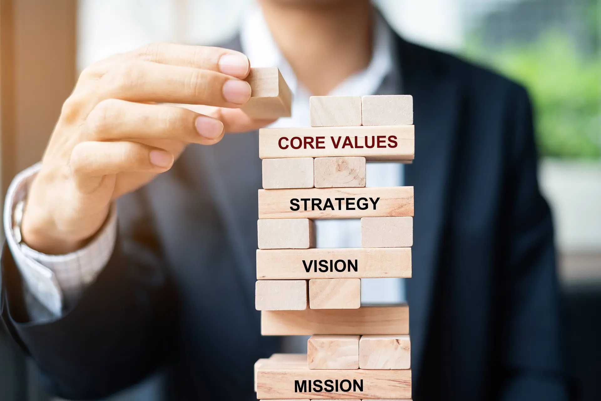 Wooden blocks stacked with mission, vision, strategy showing step-by-step telecom digital transformation needed to reduce operating costs